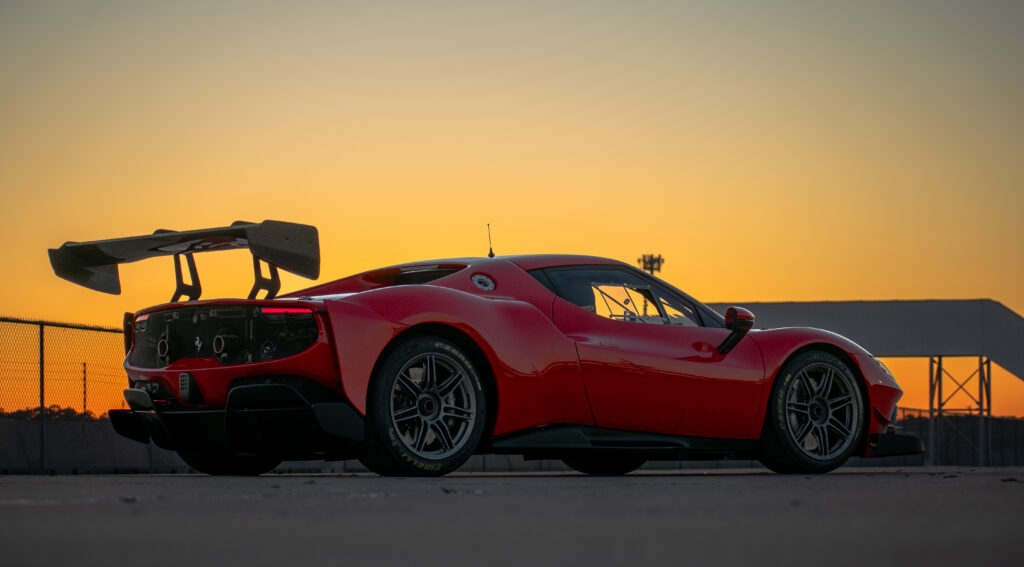 Red race car in the paddock at sunset